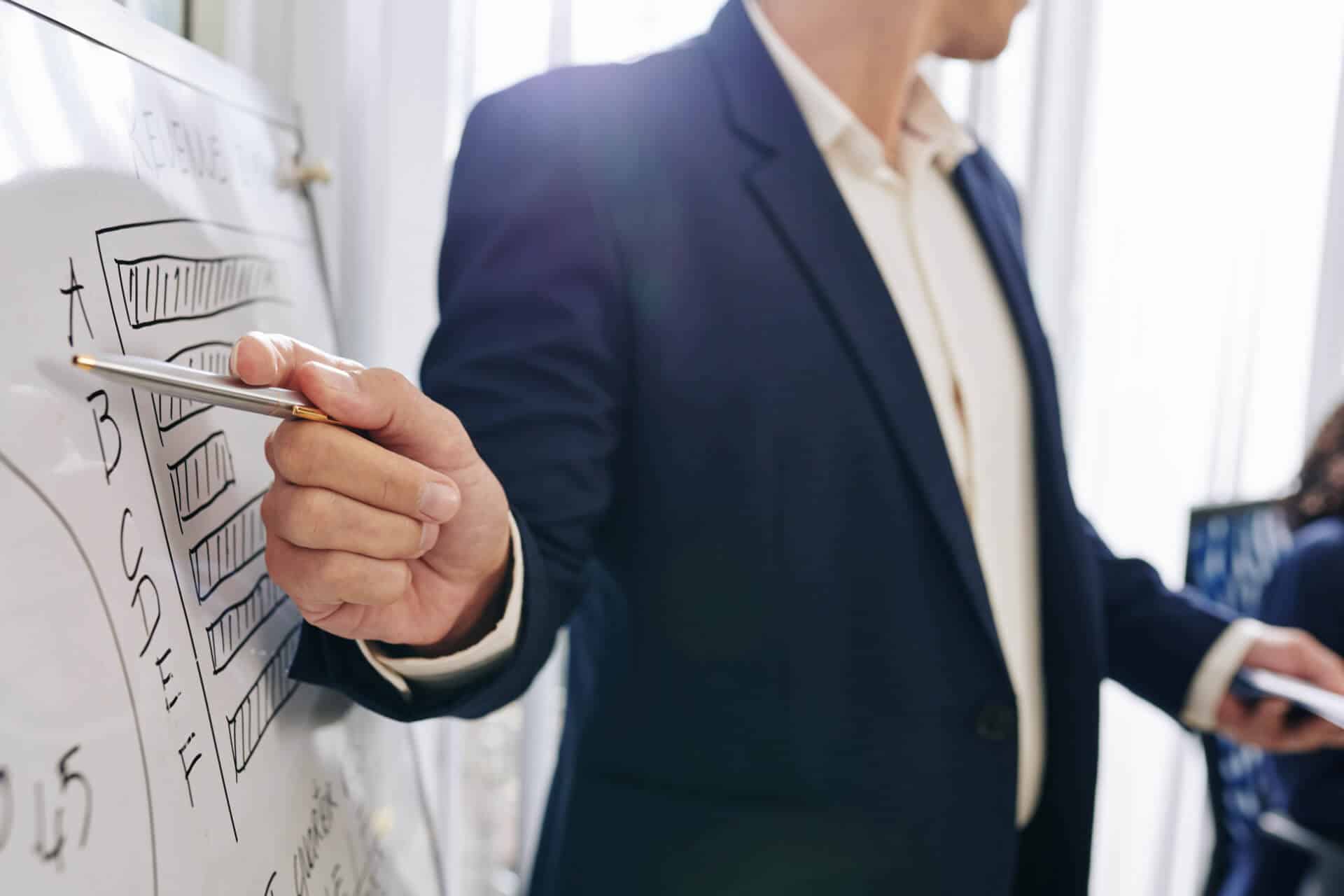 man pointing to list on whiteboard