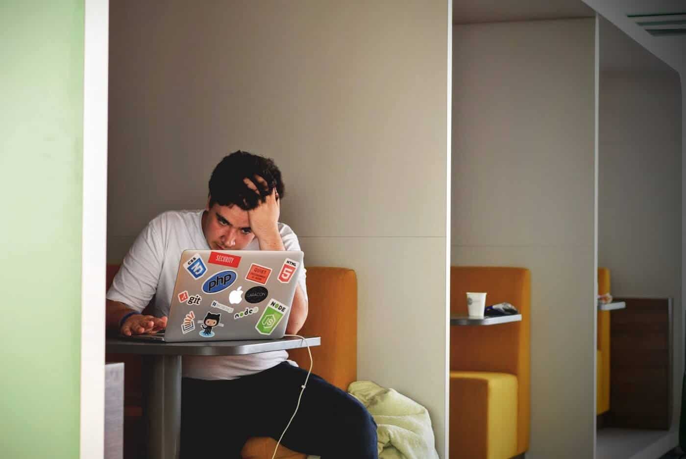 Man struggling while looking at laptop